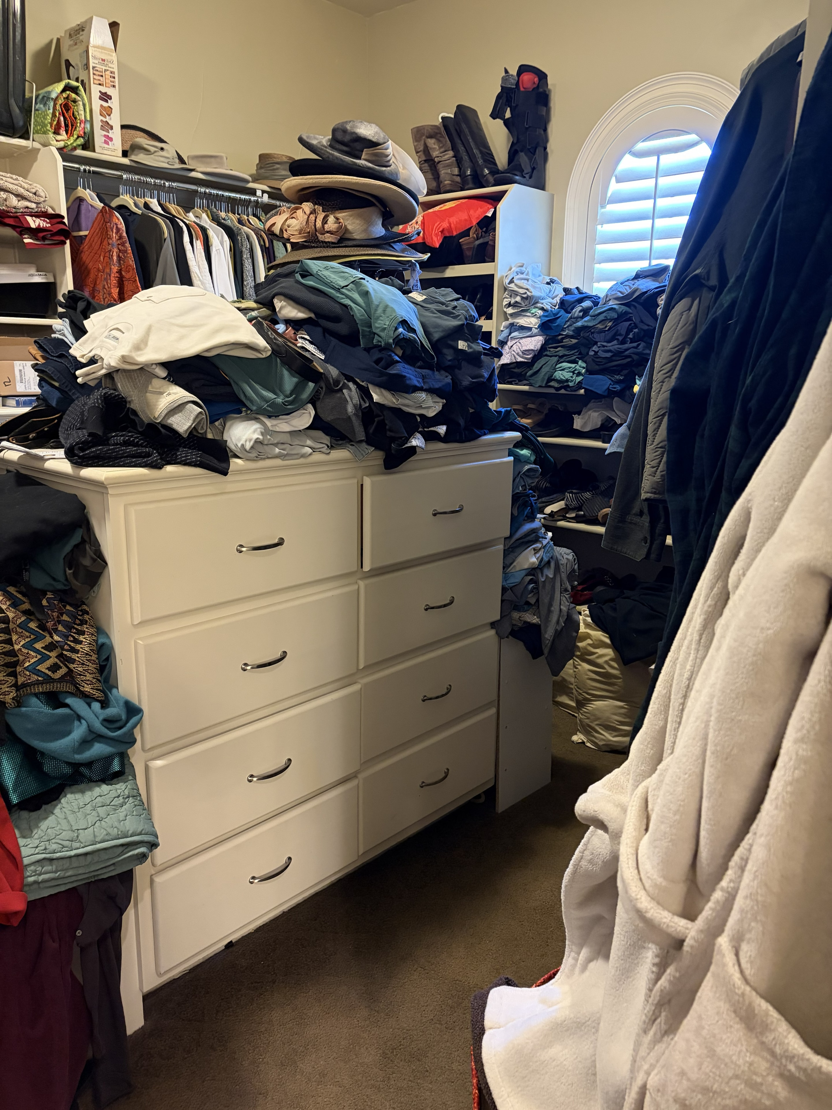 Closet before organizing — cluttered with clothes
